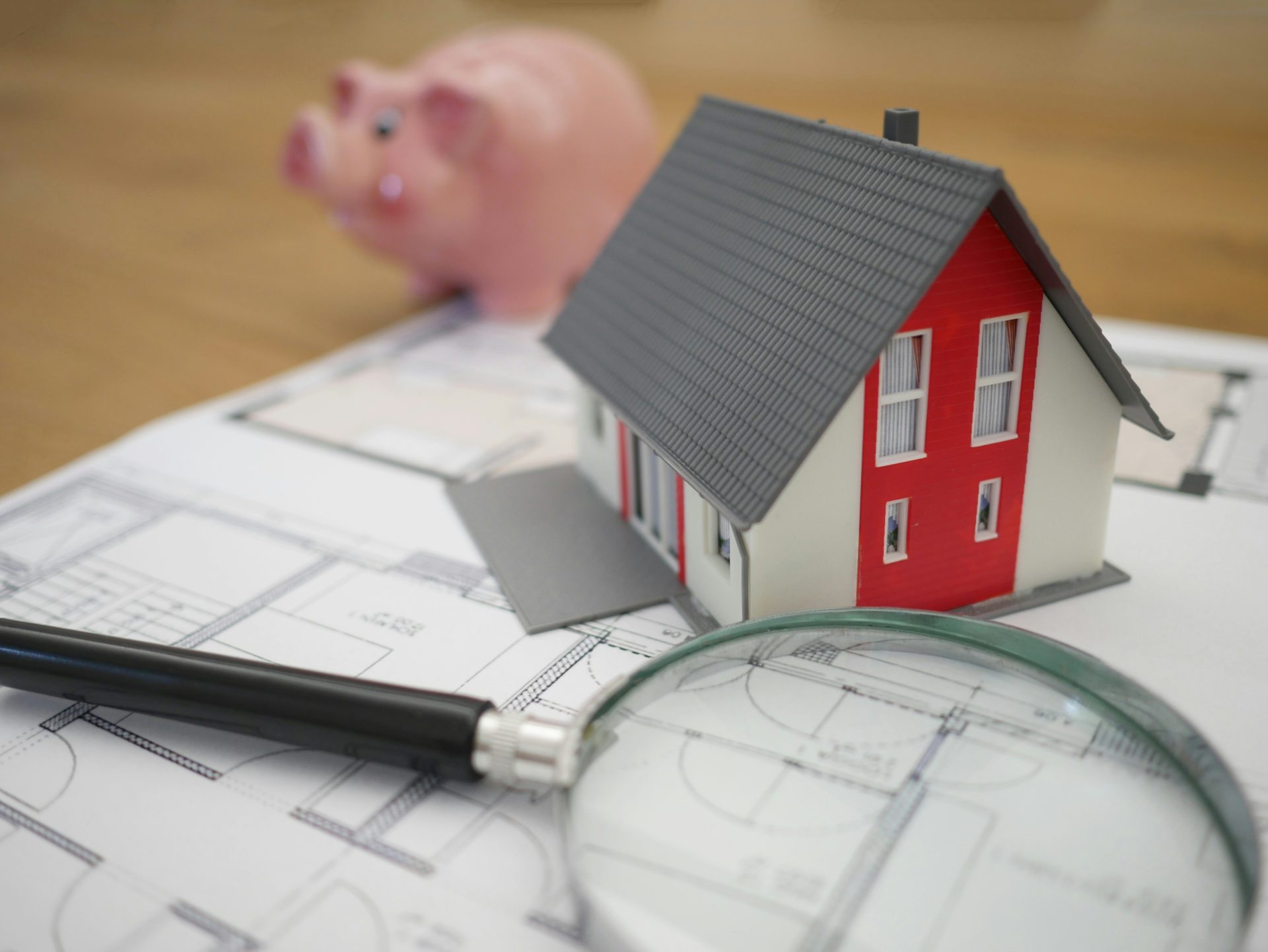 maison en bois blanche et rouge à côté d'une loupe à cadre gris